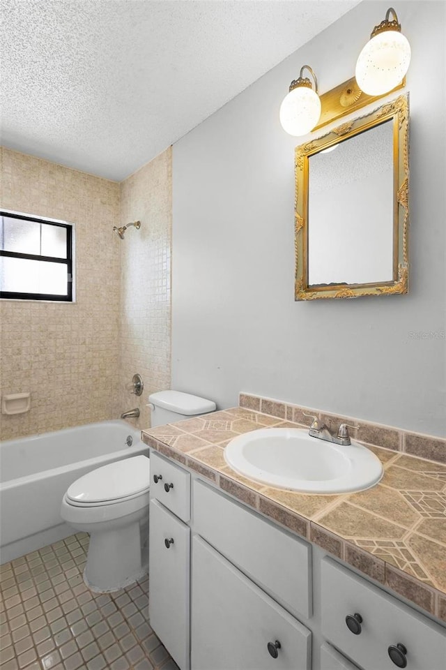 bathroom with tile patterned floors, a textured ceiling, shower / bathing tub combination, vanity, and toilet
