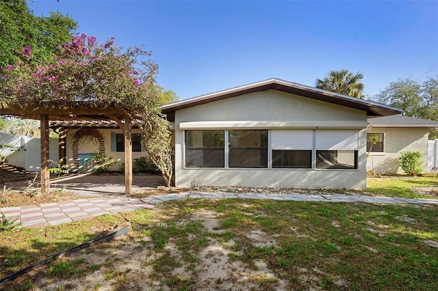 rear view of house featuring stucco siding, fence, and a patio