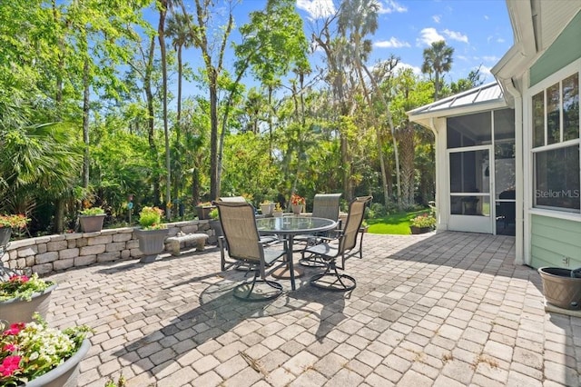 view of patio featuring a sunroom and outdoor dining space