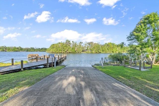 dock area featuring a water view and a lawn