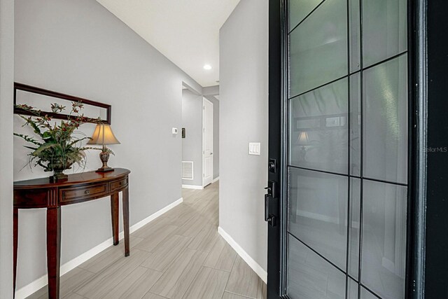 interior space with wood tiled floor, baseboards, and visible vents