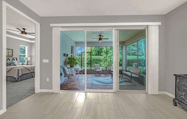 doorway to outside featuring ceiling fan, baseboards, and wood finish floors