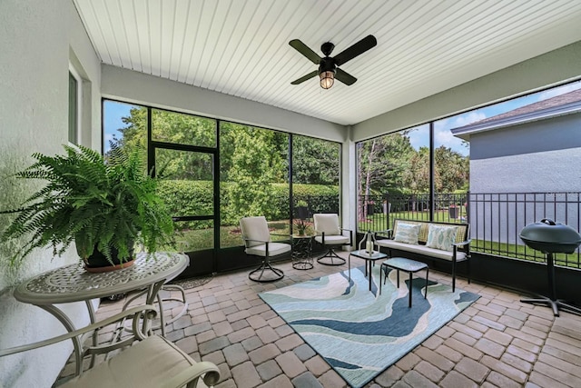 sunroom / solarium with an outdoor living space and a ceiling fan