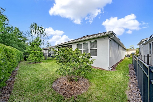 view of home's exterior featuring a fenced backyard, stucco siding, and a lawn