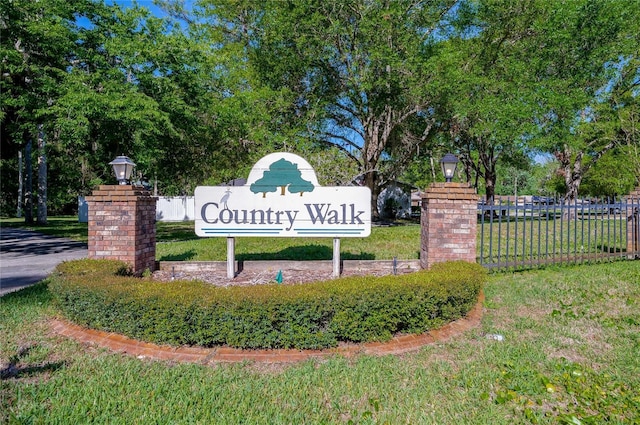 community / neighborhood sign with fence and a yard