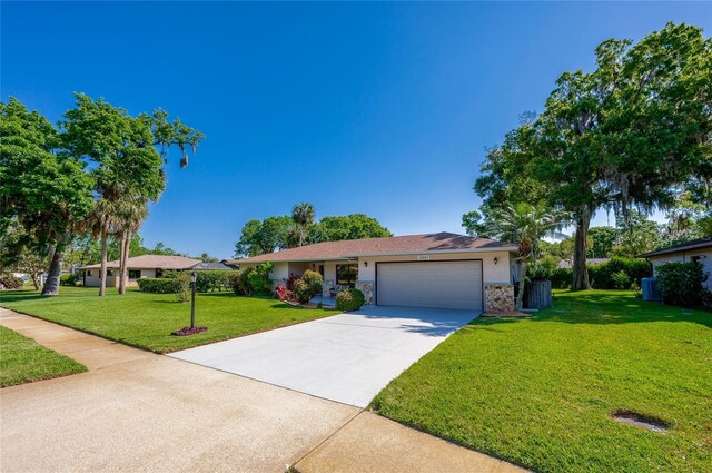 ranch-style house featuring a front lawn, stone siding, concrete driveway, a garage, and stucco siding