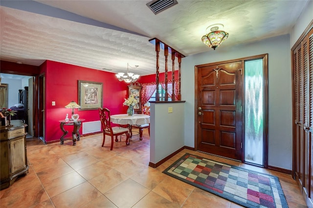foyer entrance with an inviting chandelier, visible vents, and baseboards