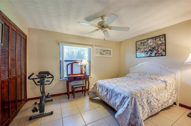 bedroom featuring a closet, a ceiling fan, baseboards, and light tile patterned floors