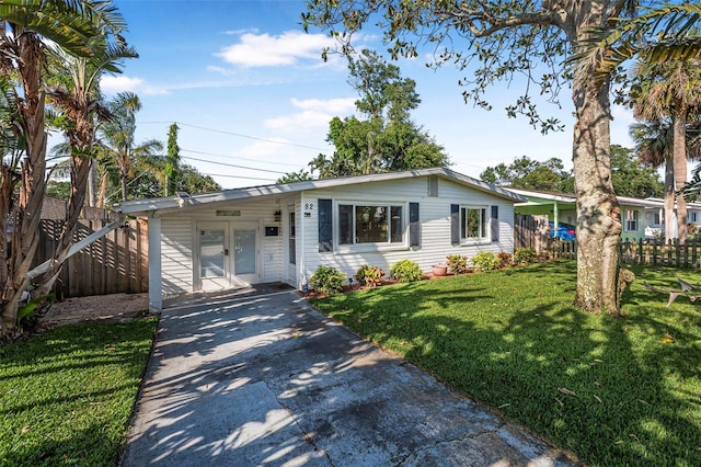 82 Margaret Rd, Ormond Beach, FL 32176 - view of front of property with french doors, driveway, fence, and a front lawn
