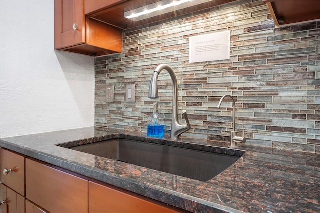 82 Margaret Rd, Ormond Beach, FL 32176 - kitchen featuring dark stone countertops, a sink, and backsplash