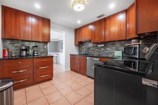 82 Margaret Rd, Ormond Beach, FL 32176 - kitchen with a sink, visible vents, brown cabinets, and stainless steel appliances