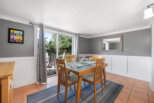 82 Margaret Rd, Ormond Beach, FL 32176 - dining area with light tile patterned floors and a wainscoted wall