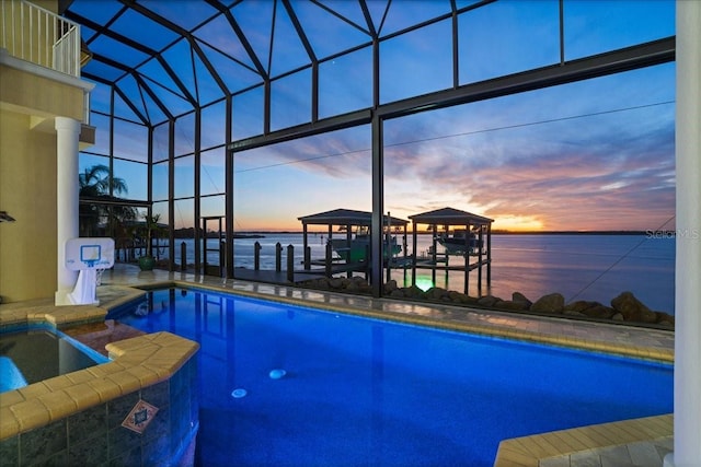3310 John Anderson Dr, Ormond Beach, FL 32176 - pool at dusk with a lanai, a pool with connected hot tub, and a water view
