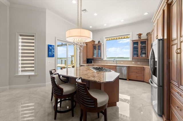 3310 John Anderson Dr, Ormond Beach, FL 32176 - kitchen featuring brown cabinetry, visible vents, a breakfast bar, a center island, and stainless steel appliances