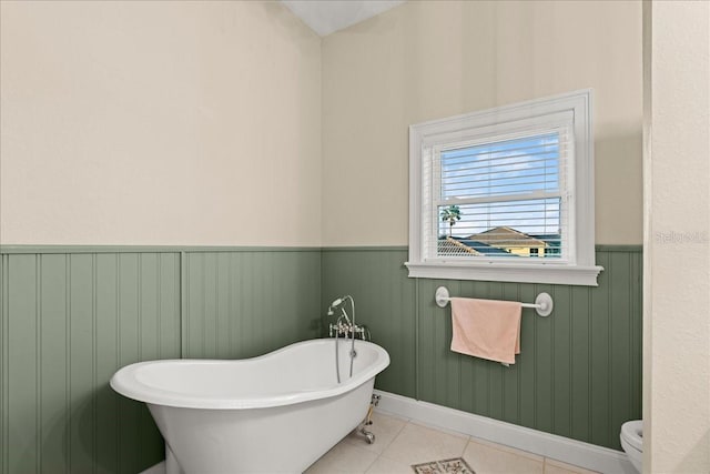 3310 John Anderson Dr, Ormond Beach, FL 32176 - bathroom with tile patterned floors, a freestanding tub, wainscoting, and toilet