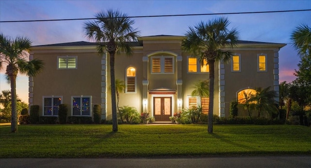 3310 John Anderson Dr, Ormond Beach, FL 32176 - view of front facade with french doors, stucco siding, and a lawn