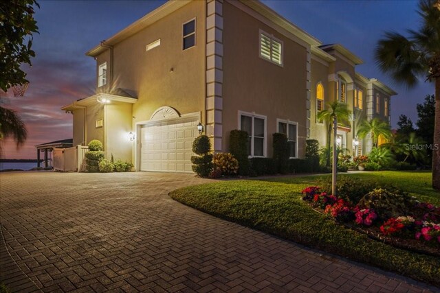 3310 John Anderson Dr, Ormond Beach, FL 32176 - view of side of home with an attached garage, stucco siding, and decorative driveway