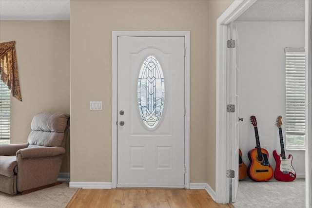 entrance foyer featuring baseboards and light wood finished floors
