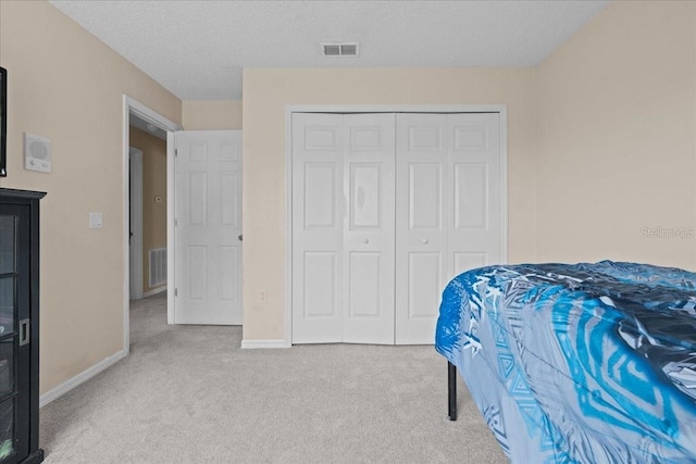 bedroom featuring carpet floors, baseboards, a closet, and visible vents
