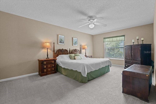 carpeted bedroom featuring baseboards, ceiling fan, and a textured ceiling