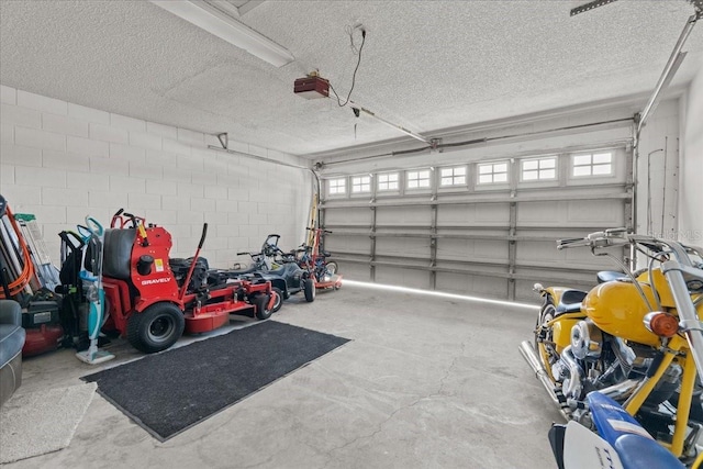 garage featuring concrete block wall and a garage door opener