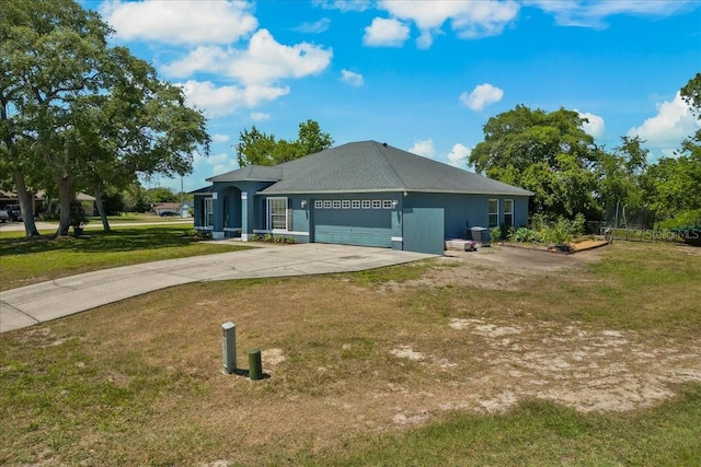 view of side of property featuring concrete driveway, a lawn, and a garage