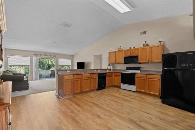 kitchen with light wood-style floors, a peninsula, open floor plan, visible vents, and black appliances