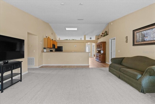 living area featuring visible vents, arched walkways, light colored carpet, and lofted ceiling