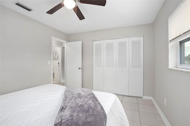 bedroom with baseboards, a closet, light tile patterned floors, a ceiling fan, and visible vents