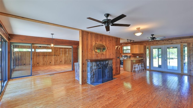 160 Rose Ave, Lake Helen, FL 32744 - unfurnished living room with light wood-style floors, wood walls, a ceiling fan, and french doors