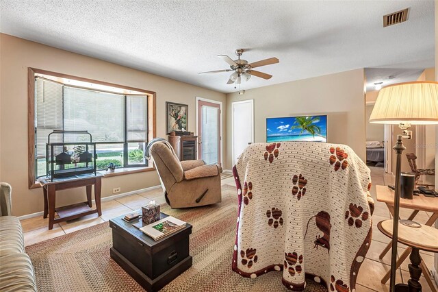 8 Faith Ln, Palm Coast, FL 32137 - living area featuring ceiling fan, light tile patterned floors, a textured ceiling, visible vents, and baseboards