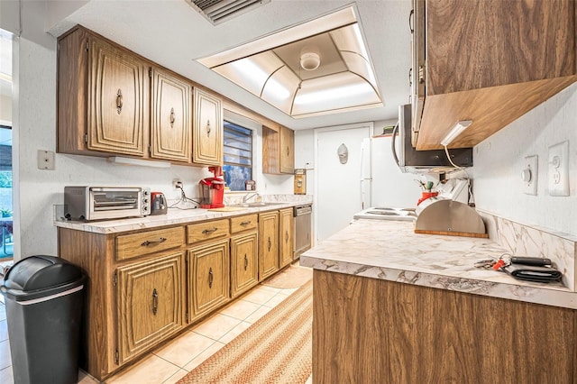 8 Faith Ln, Palm Coast, FL 32137 - kitchen with light tile patterned floors, stainless steel dishwasher, visible vents, light countertops, and a toaster