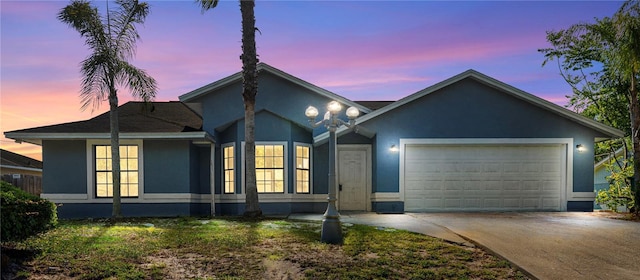 view of front of home with an attached garage, driveway, and stucco siding