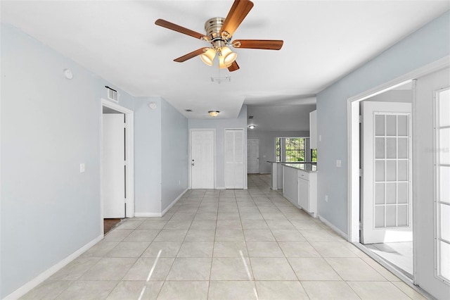 interior space featuring visible vents, baseboards, a ceiling fan, and light tile patterned floors