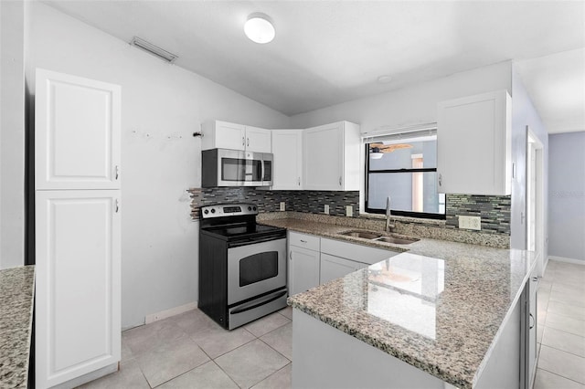 kitchen with a sink, white cabinets, appliances with stainless steel finishes, and decorative backsplash