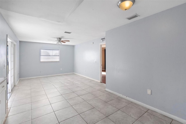 spare room featuring visible vents, baseboards, light tile patterned flooring, and ceiling fan