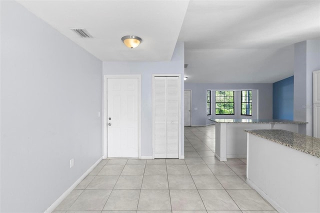 foyer with light tile patterned floors, visible vents, and baseboards