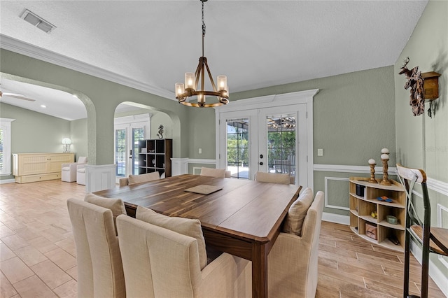 dining area with french doors, arched walkways, an inviting chandelier, and visible vents