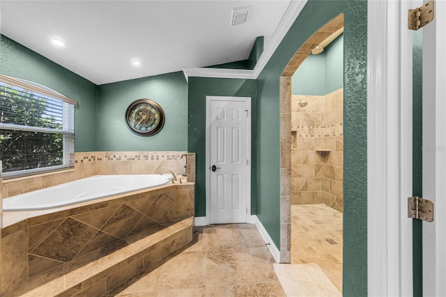 bathroom with a tile shower, a bath, a textured wall, and baseboards