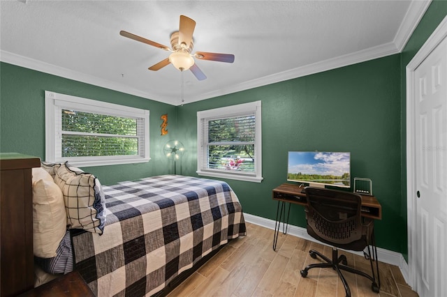 bedroom featuring ornamental molding, a closet, multiple windows, and wood finished floors