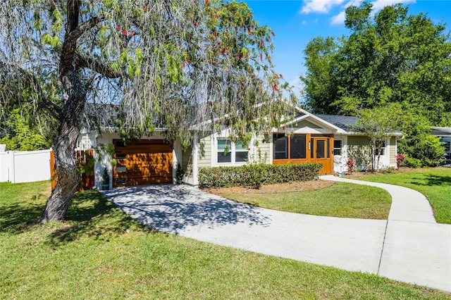 view of front of house featuring an attached garage, driveway, fence, and a front lawn