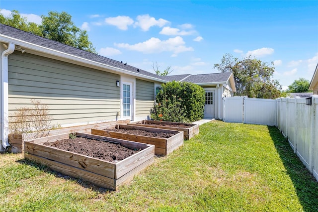 rear view of house with a garden, a yard, a fenced backyard, and a gate
