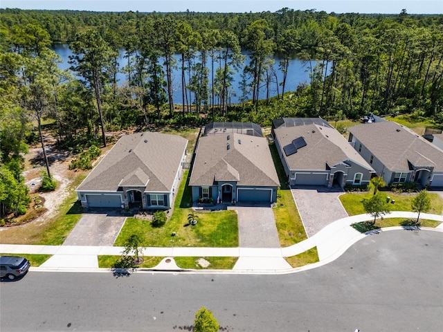 drone / aerial view with a water view, a residential view, and a forest view