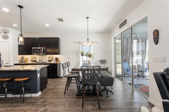 dining area with dark wood-type flooring, visible vents, and recessed lighting