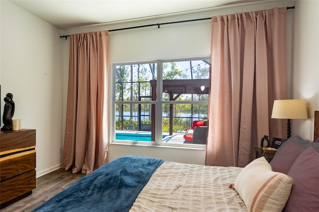 bedroom featuring multiple windows and wood finished floors