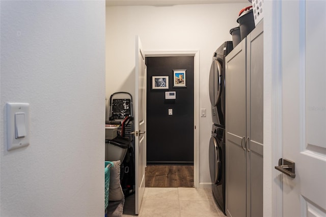 laundry area featuring laundry area, light tile patterned floors, and stacked washer / drying machine