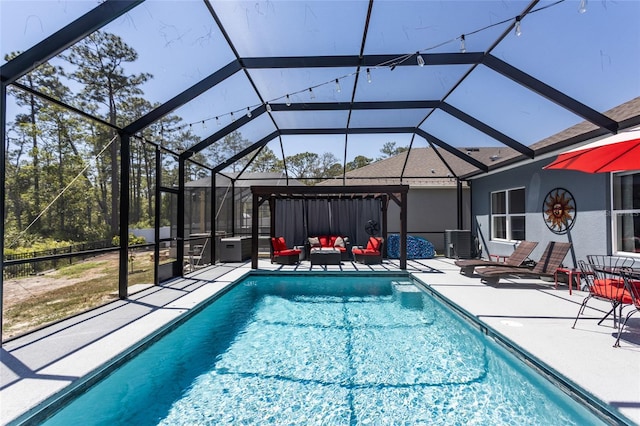 pool with a patio, an outdoor hangout area, and glass enclosure