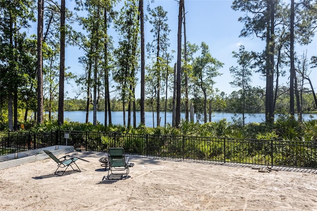 view of patio / terrace featuring a water view and fence