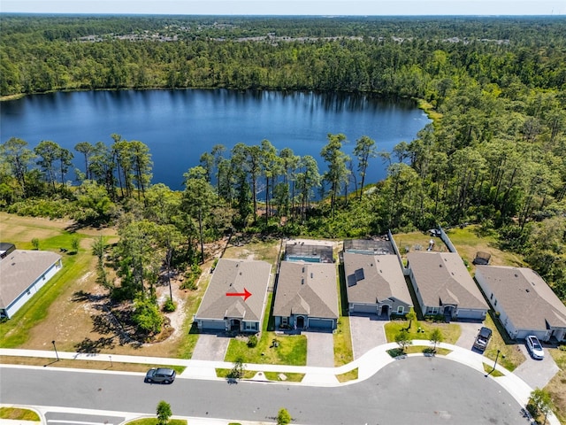 drone / aerial view featuring a water view, a view of trees, and a residential view