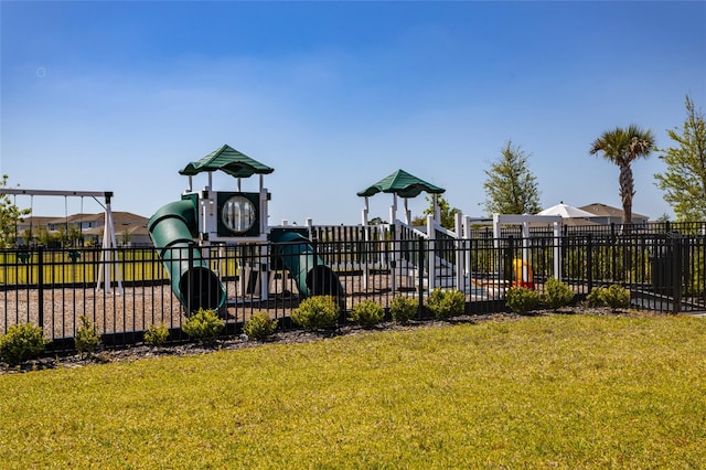 community play area featuring a yard and fence